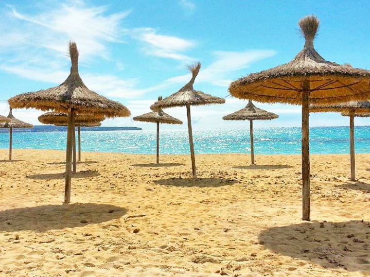 A sunny beach with umbrellas at Palma, Majorca.